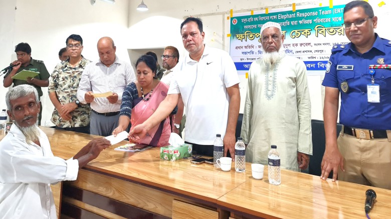 ছবির ক্যাপশন: বন্য হাতি দ্বারা ক্ষতিগ্রস্ত পরিবারের সদস্যদের মধ্যে ক্ষতিপূরণের চেক বিতরণ করছেন শ্রীবরদী-ঝিনাইগাতী আসনের সংসদ সদস্য মো. মাহমুদুল হক রুবেল।